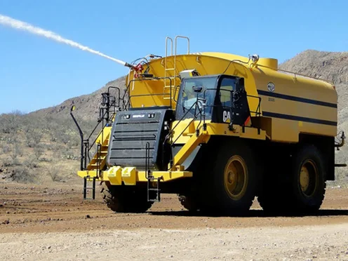 Yellow mining water dumper spraying water in a quarry